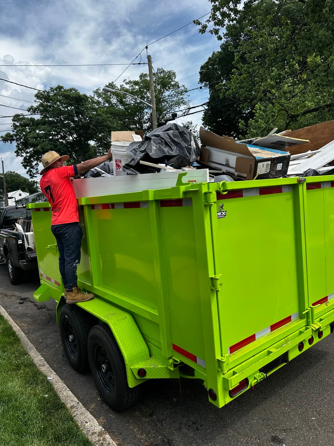 Junkfire crew member loading the bright green removal trailer